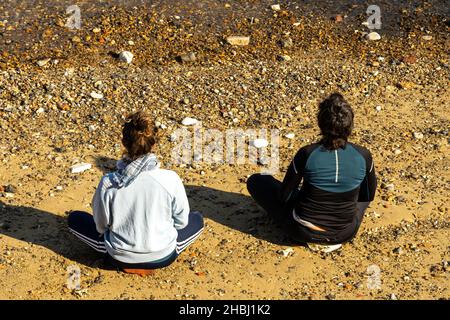 London, Greenwich Vereinigtes Königreich - 24th 2021. April: Zwei Frauen meditieren am Ufer der Themse in Greenwich Stockfoto