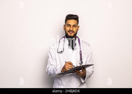 Ein junger Arzt, der auf einem medizinischen Horoskop schreibt Stockfoto