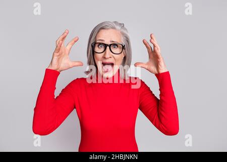 Foto von unglücklich verängstigt alte Frau heben Hände tragen Brille Schrei verängstigt isoliert auf grauem Hintergrund Stockfoto