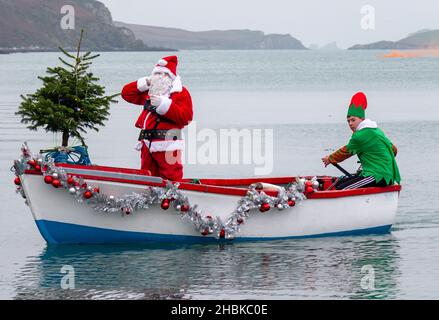 Weihnachtsmann oder Weihnachtsmann, der mit seinem Elf auf dem Boot ankommt Stockfoto