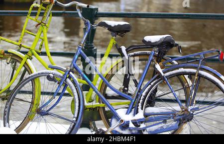 Nahaufnahme von verschneiten Fahrrädern auf einer Brücke in Amsterdam Stockfoto