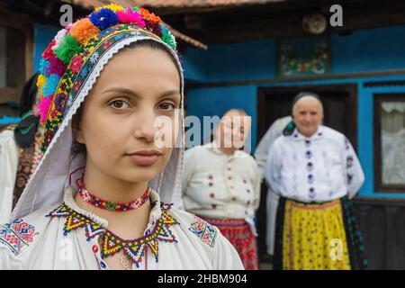 Salaj, Transylvania, Rumänien- 14. Mai 2018: Schöne junge Braut in rumänischer Volkstracht, eine traditionelle Hochzeit in einem charmanten blauen alten Haus Stockfoto