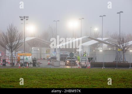 Das Bild vom 19th 2021. Dezember zeigt die geschäftige Fahrt durch das Testzentrum in Milton, Cambridge, unter Flutlicht an einem nebligen Sonntagmorgen, während die Leute zu ihren PCR-Tests gehen. Mit der Zunahme der Omicron-Fälle steigt die Nachfrage nach Tests, da einige Personen keinen Platz für einen Test buchen oder Testkits zu Hause erhalten können. Stockfoto