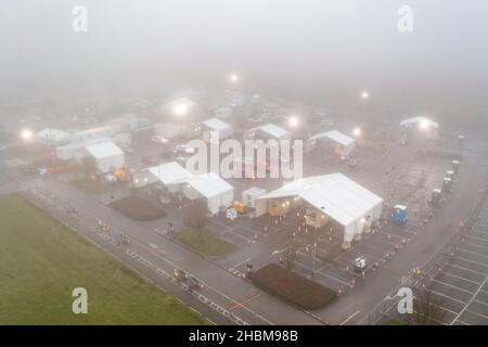 Das Bild vom 19th 2021. Dezember zeigt die geschäftige Fahrt durch das Testzentrum in Milton, Cambridge, unter Flutlicht an einem nebligen Sonntagmorgen, während die Leute zu ihren PCR-Tests gehen. Mit der Zunahme der Omicron-Fälle steigt die Nachfrage nach Tests, da einige Personen keinen Platz für einen Test buchen oder Testkits zu Hause erhalten können. Stockfoto