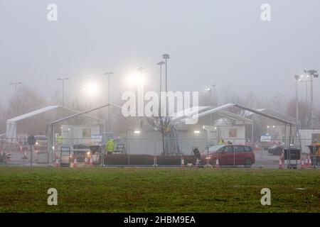 Das Bild vom 19th 2021. Dezember zeigt die geschäftige Fahrt durch das Testzentrum in Milton, Cambridge, unter Flutlicht an einem nebligen Sonntagmorgen, während die Leute zu ihren PCR-Tests gehen. Mit der Zunahme der Omicron-Fälle steigt die Nachfrage nach Tests, da einige Personen keinen Platz für einen Test buchen oder Testkits zu Hause erhalten können. Stockfoto