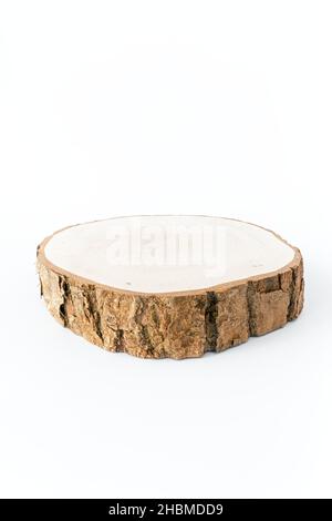 Frisch geschnittene Holzscheibe mit Rinde isoliert auf weißem Hintergrund. Low-Angle-Ansicht. Stockfoto