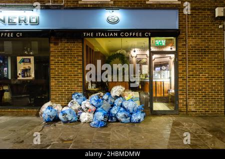 Müllsäcke stapelten sich nach Geschäftsschluss vor einem Café und warteten darauf, von Müllsammlern abgeholt zu werden. Stockfoto