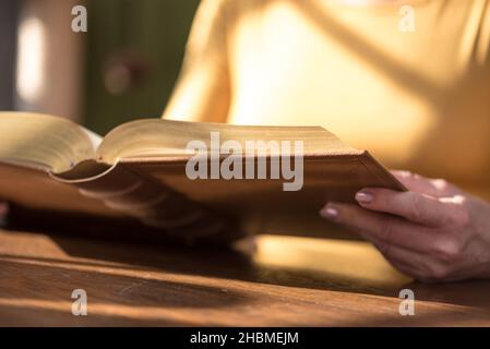 Nahaufnahme einer Frau, die ein Buch liest, hartes Licht Stockfoto