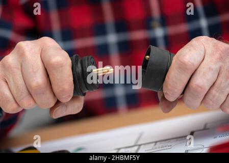 Elektroinstallateur hält Elektrostecker in der Hand Stockfoto