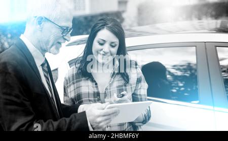 Autoverkäufer gibt Erklärungen auf Tablette, um hübsche junge Frau; Mehrfachbelichtung Stockfoto
