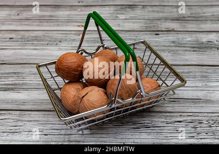 Walnussfrüchte liegen in einem kleinen Eisenkorb. Hochwertige Fotos Stockfoto