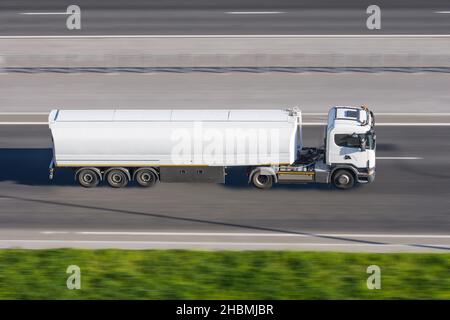 LKW mit Anhängertank rast entlang der Autobahn Stockfoto