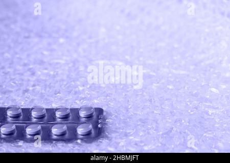 Eine Blister aus weichen beigen Pillen in der Mitte auf weißem Blasenhintergrund. Monochrome, einfache, flache Laie mit pastellfarbener Textur. Medizinisches Konzept. Trendy, minimal Stockfoto