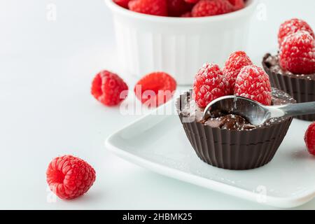 Schokoladen-Himbeer-Mousse mit einem Löffel auf einer kleinen Platte. Stockfoto