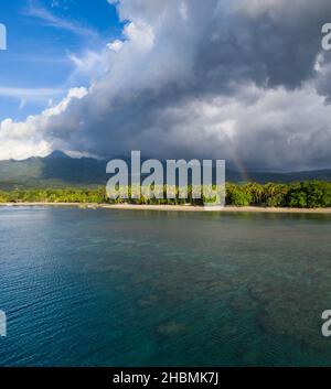 Wolken treiben über die Küste von Maumere auf der tropischen Insel Flores in Indonesien. Diese wunderschöne und abgelegene Gegend liegt auf den Kleinen Sundainseln. Stockfoto