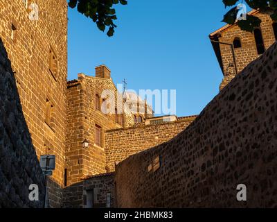 Vulkanische Steinmauern und Dächer der Kathedrale von Le Puy-en-Velay, Frankreich, aufgenommen während der goldenen Stunden am Abend ohne Menschen Stockfoto