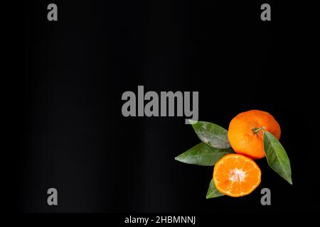 Mandarinen auf schwarzem Hintergrund, mit viel Kopierplatz Stockfoto