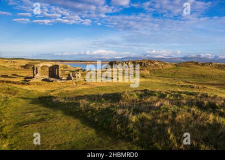 Das keltische Kreuz und die Ruinen der St. Dwynwen-Kirche auf der Insel Llanddwyn, Isle of Anglesey, Nordwales Stockfoto
