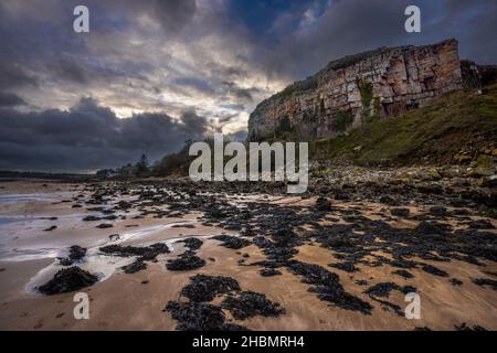 Ein Blick auf den Castell Mawr Rock am Nachmittag im Winter auf Red Wharf Bay bei Ebbe im Winter, Anglesey, Nordwales Stockfoto