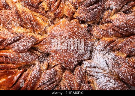 Weihnachten Stern geflochtene Brot Textur geröstete hausgemachte Brote mit Zimt. Traditionelles Sauerteig-Brot in Scheiben geschnitten auf einem rustikalen Holz Stockfoto