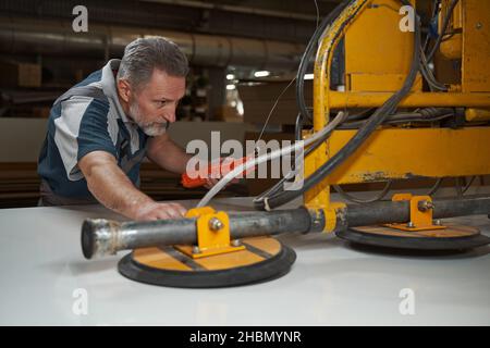 Fokussiertes Foto von einem ernsthaften Mann, der professionelle Ausrüstung testet Stockfoto