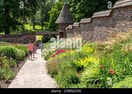 Besucher genießen die Sommergärten am Knightshayes Court in der Nähe von Tiverton, Devon, Großbritannien Stockfoto