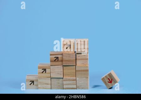 Holzwürfel bilden eine Treppe mit Pfeilen nach oben, aber der letzte Würfel fällt nach unten, Konzept für das Risiko des Scheiterns durch zu schnell Stockfoto