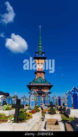 Sapanta, Rumänien-19. August 2021: Foto aus der Ferne, unter den blau gemalten Kreuzen, der Kirche mit dem Turm, der für die Region spezifisch ist Stockfoto