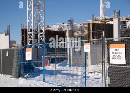 Baustelle mit Kranen und Zäunen mit Warnschildern. Stockfoto