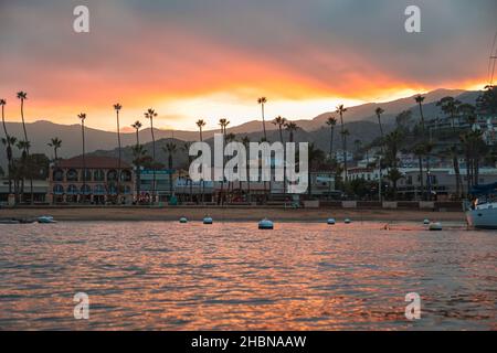 AVALON, VEREINIGTE STAATEN - Nov 21, 2021: Ein farbenfroher Sonnenuntergang mit der Stadt Avalon über dem Pazifischen Ozean. Stockfoto