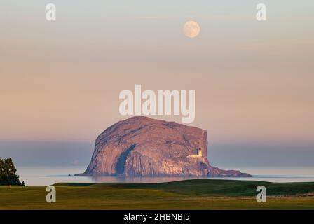 Bass Rock mit Dunst- und Nebelbank und Vollmond bei Sonnenuntergang, Firth of Forth, Schottland, Großbritannien Stockfoto