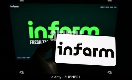 Person, die Smartphone mit Logo der deutschen Firma infarm - Indoor Urban Farming GmbH auf dem Bildschirm vor der Website hält. Konzentrieren Sie sich auf die Telefonanzeige. Stockfoto