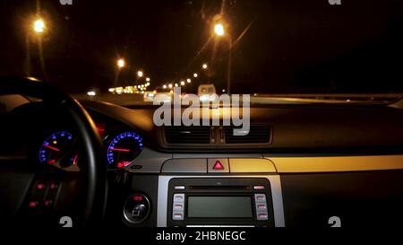 Autofahren bei Nacht. Auto fahren in der Stadt Blick aus dem Inneren. Zeitraffer des nächtlichen Fahrens mit Kamera im Auto. Stockfoto