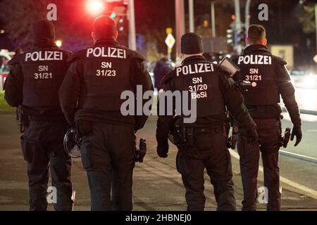 Freiberg, Deutschland. 20th Dez 2021. Vier Polizisten gehen eine Straße entlang. Bei der Kundgebung unter dem Motto „Vernunft statt Angst“, initiiert vom Bündnis „Freiberg für alle“, distanzieren sich die Bewohner von den regelmäßigen Versammlungen von Gegnern der aktuellen Gesundheitspolitik in der Stadt. Quelle: Daniel Schäfer/dpa-Zentralbild/dpa/Alamy Live News Stockfoto