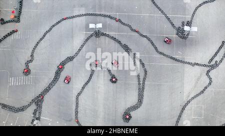 Luftaufnahme der Kartbahn mit beweglichen kleinen roten Karts, Renn- und Motorsport-Konzept. Draufsicht auf Kurven auf der Kart-Rennstrecke. Stockfoto