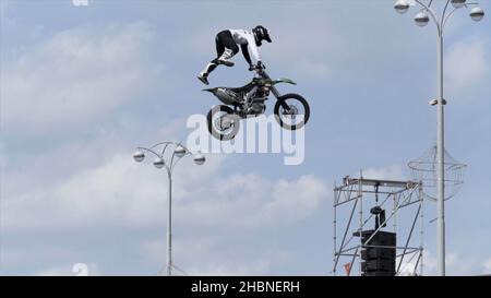 Italien - Verona, 05.14.2019: freestyle Motorradfahrer macht atemberaubende Trick auf blau bewölkten Himmel Hintergrund. Sportveranstaltung, Wettbewerb im Freien. Stockfoto