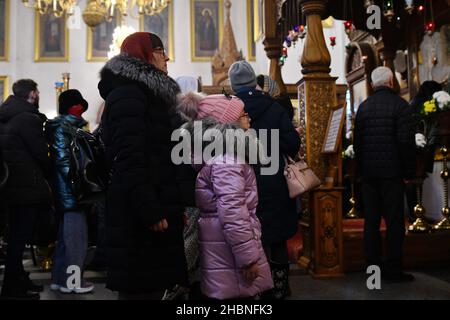 Swjatohirsk, Ukraine. 19th Dez 2021. Eine Frau mit ihrem jungen Mädchen hat in der Mariä Himmelfahrt-Kathedrale gebetet.die Heilige Himmelfahrt Sviatohirsk Lavra ist ein wichtiges geistliches Zentrum der Ostukraine. Das orthodoxe Kloster befindet sich am rechten hohen Kreideufer des Flusses Siverskyi Donez (auf den sogenannten Heiligen Bergen) in der Stadt Swjatohirsk im Norden der Region Donezk. Kredit: SOPA Images Limited/Alamy Live Nachrichten Stockfoto