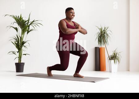 Motivierte afroamerikanische Dame in Sportkleidung, die Übungen macht Stockfoto