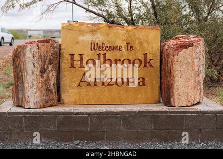 Willkommen bei Holbrook Arizona Schild mit Stücken von versteinerten Bäumen daneben Stockfoto