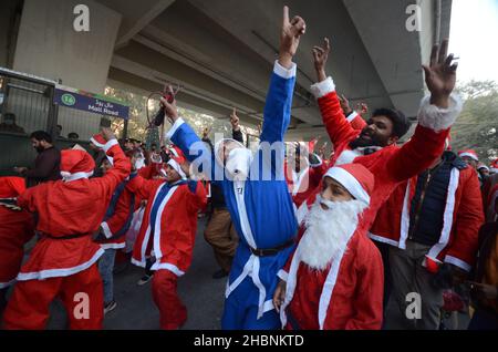 Peshawar, Peshawar, Pakistan. 20th Dez 2021. Mitglieder der christlichen Minderheit Pakistans, die als Weihnachtsmänner gekleidet ist, nehmen an einer vorweihnachtlichen Kundgebung auf einer Straße in Peshawar Teil. Pakistan ist ein muslimisches Land mit sunnitischer Mehrheit und vier Millionen Christen bei einer Gesamtbevölkerung von etwa 200 Millionen Menschen. (Bild: © Hussain Ali/Pacific Press via ZUMA Press Wire) Stockfoto