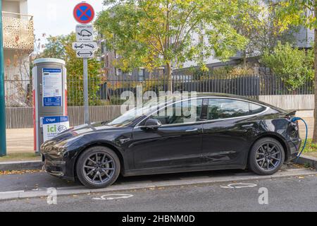 Gennevilliers, Frankreich - 11 13 2021: Grünes Elektroauto, das auf dem Gehweg gesäumt ist Stockfoto