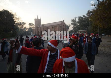 Peshawar, Peshawar, Pakistan. 20th Dez 2021. Mitglieder der christlichen Minderheit Pakistans, die als Weihnachtsmänner gekleidet ist, nehmen an einer vorweihnachtlichen Kundgebung auf einer Straße in Peshawar Teil. Pakistan ist ein muslimisches Land mit sunnitischer Mehrheit und vier Millionen Christen bei einer Gesamtbevölkerung von etwa 200 Millionen Menschen. (Bild: © Hussain Ali/Pacific Press via ZUMA Press Wire) Stockfoto