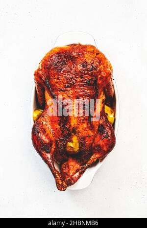 Gebratene Ente gefüllt mit Äpfeln in orangefarbener Glasur auf weißem Hintergrund, festliches weihnachtsrezept. Draufsicht mit Kopierbereich Stockfoto