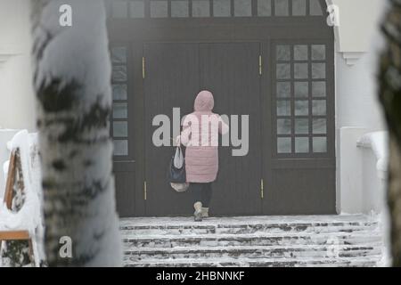 Ein Mann tritt in ein schönes Gebäude ein, eine große Holztür. Hochwertige Fotos Stockfoto