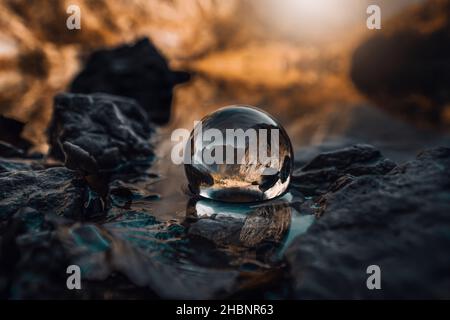Eine Nahaufnahme einer Kristallkugel mit der Reflexion von Felsen Stockfoto