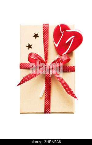 Geschenkbox mit rotem Band und herzförmigem Lollipop auf weißem Hintergrund mit Clipping-Pfad isoliert dekoriert. Draufsicht, Platz für Text kopieren Stockfoto