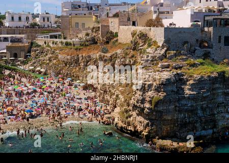 Polignano a Mare, Süditalien Provinz Bari - berühmter Strand Lama Monachile zwischen steilen Klippen und weißen Gebäuden Stockfoto