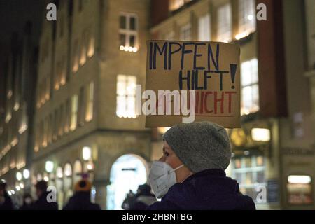 Münster, NRW, Deutschland. 20th Dez 2021. Ein Protestler mit dem Plakat „Impulse Hilfe, AFD nicht“. Aktivisten und Demonstranten aus mehreren Organisationen haben sich im Stadtzentrum versammelt, um gegen Verschwörungstheorien, Rassismus, antisemitismus und soziale Segregation sowie gegen Impfungen zu protestieren. Kredit: Imageplotter/Alamy Live Nachrichten Stockfoto
