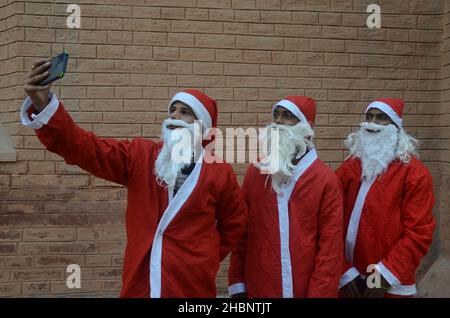 Peshawar, Pakistan. 20th Dez 2021. (12/20/2021) Mitglieder der christlichen Minderheit Pakistans, die als Weihnachtsmänner gekleidet ist, nehmen an einer vorweihnachtlichen Kundgebung auf einer Straße in Peshawar Teil. Pakistan ist ein muslimisches Land mit sunnitischer Mehrheit und vier Millionen Christen bei einer Gesamtbevölkerung von etwa 200 Millionen Menschen. (Foto: Hussain Ali/Pacific Press/Sipa USA) Quelle: SIPA USA/Alamy Live News Stockfoto