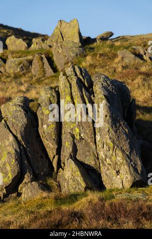 Eine vertikale Aufnahme von moosigen Felsen in einer bergigen Gegend Stockfoto